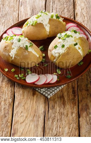 Jacket Potatoes Stuffed With Salted Curd Cheese And Green Onions Close-up In A Plate On A Wooden Tab