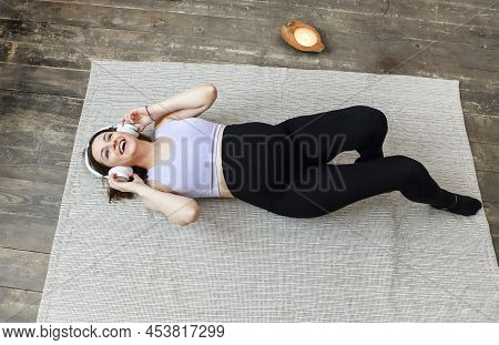 Image Of An Amazing Healthy Pregnant Woman Indoors At Home On The Floor By Sofa Listening Music With