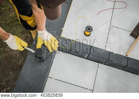 Caucasian Professional Landscaper Building Residential Patio Made From Concrete Bricks. Landscaping 