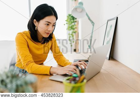 Young Asian Woman Using A Laptop Computer While Studying Online From Home. Education And Technology 