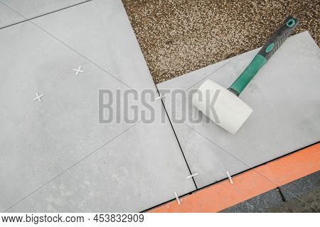 Soft Gum Made Hammer Laying On Concrete Patio Floor Blocks. Backyard Patio Flooring Theme.