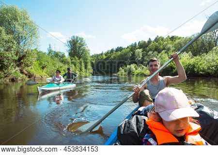 Family Kayak Trip. Father And Daughter, And Elderly Couple Senior And Seniora Rowing Boat On The Riv