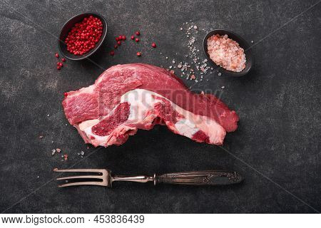 Raw Beef Meat. Rough Piece Of Meat On Bone For Roast Or Soup With Salt, Pepper, Thyme And Rosemary O