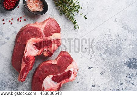 Raw Beef Meat. Rough Piece Of Meat On Bone For Roast Or Soup With Salt, Pepper, Thyme And Rosemary O