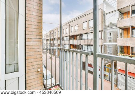 Balcony With A Metal Railing In A Cozy House Overlooking The Sityscape
