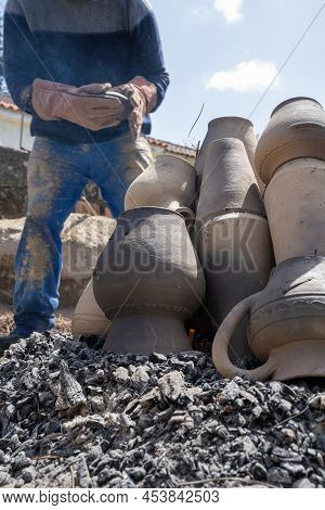 Amarante, Portugal - April 30: Stacking The Pieces Of Clay On The Embers Of The Bonfire During The F