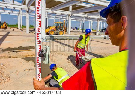Zrenjanin, Vojvodina, Serbia - April 26, 2018: Construction Worker Is Holding Leveling Rod To Help S