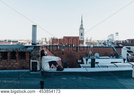 Unhappy Young Woman Resting And Sitting On The Roof With City View.