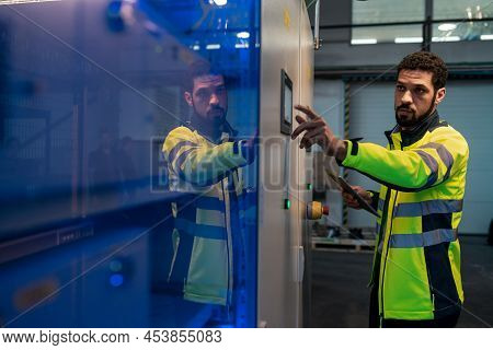 Young Industrial Worker Operating Cnc Machine At Metal Machining Industry