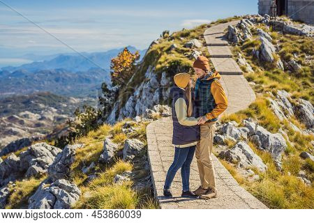 Couple Man And Woman Tourists In Mountain Landscape At National Park Lovcen, Montenegro. Travel To M