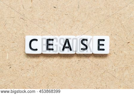 White Tile Alphabet Letter With Word Cease On Wood Background