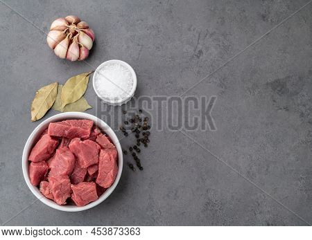 Chopped Topside Meat In A Bowl With Seasonings Over Stone Background With Copy Space.
