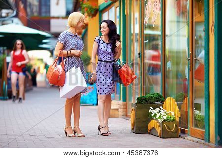 Beutful jóvenes mujeres caminando a las tiendas de la ciudad, ir de compras