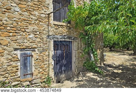 Part Of Old Building  With Ltrees In An Orchard In South Of France