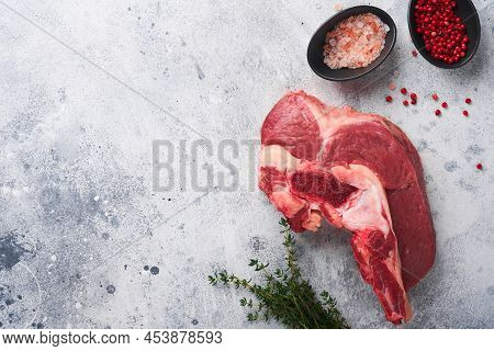 Raw Beef Meat. Rough Piece Of Meat On Bone For Roast Or Soup With Salt, Pepper, Thyme And Rosemary O