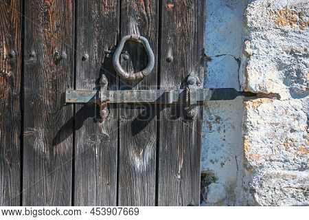 An Old Wrought Iron Door Knocker, A Metal Latch And A Lock On An Old Wooden Door In The Russian Styl