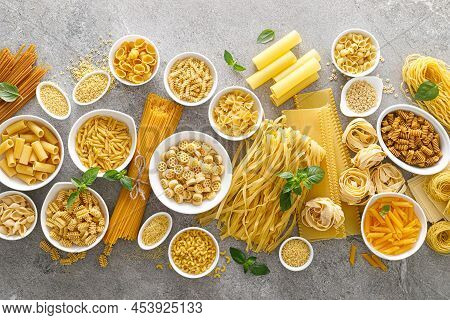 Pasta. Various Kinds Of Uncooked Pasta And Noodles Over Stone Background, Top View With Copy Space F