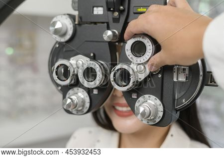 Young Female Customer Being Examined Visual Test Using Bifocal Optometry Eyesight Measurement Device