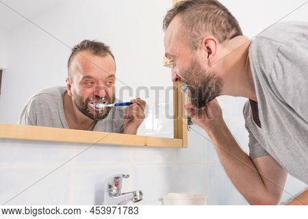 Funnny Guy Taking Care Of His Oral Hygiene, Brushing Teeth During Morning Bathroom Routine.