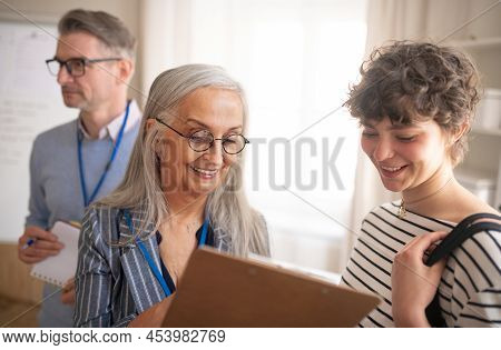 Job Centre Employee Helping Young Woman To Fill Form To Find A Job.