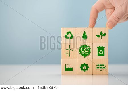 Climate Neutral Long Term Strategy. Hand Put Wooden Cubes With Green Icon And Green Icon On Blue Bac