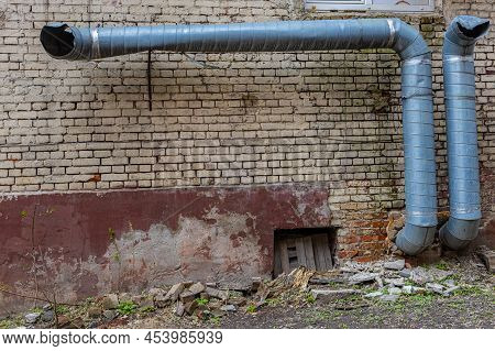 Old Duct Pipe Sticking Out Of A Brick Wall. High Quality Photo
