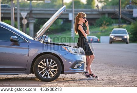Helpless Woman Standing Near Her Car With Open Hood Takling On Mobile Phone Calling Road Service For