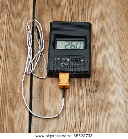 Digital thermometer on wooden table top
