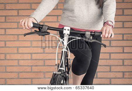 Customized fixie bike and woman over brick wall
