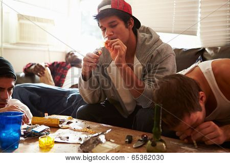 Gang Of Young Men Taking Drugs Indoors