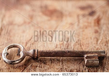 large and small rusty vintage metal keys on old wooden background, shallow dof