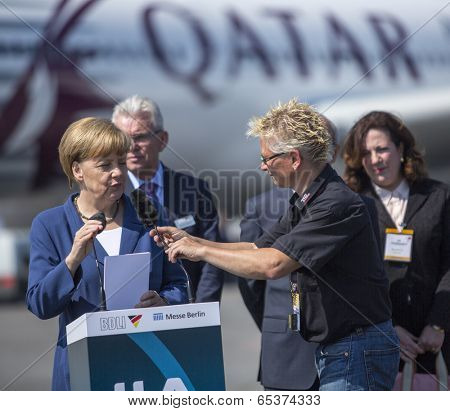 BERLIN, GERMANY - MAY 20, 2014: German Chancellor Angela Merkel (L) open up the International aviation and space exhibition ILA. In the Background, an Airbus A350.