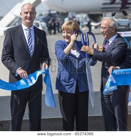 BERLIN, GERMANY - MAY 20, 2014: German Chancellor Angela Merkel (C), Turkish Minister of transport Lutfi Elvan (R) open up the International aviation and space exhibition ILA.