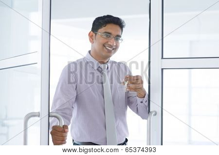 Asian Indian property agent handover new office key.