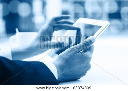 Business people using digital computer tablet concept, close up focus on hand with bokeh in blue tone.