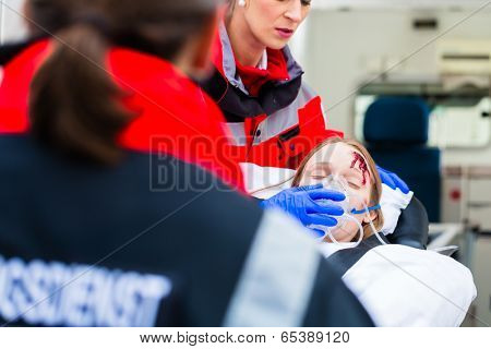 Emergency doctor and nurse or ambulance team transporting accident victim on stretcher