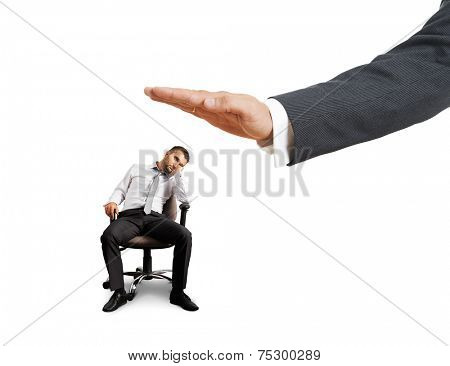 big hand ready to slap lazy businessman on the chair. photo over white background