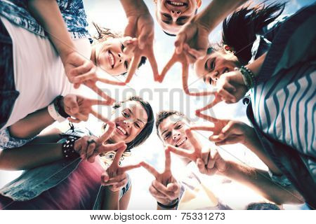 summer holidays and teenage concept - group of teenagers showing finger five gesture