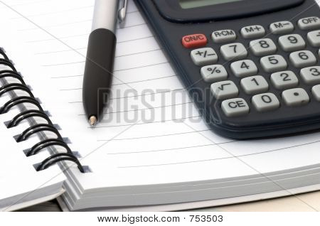 Notizbuch mit Stift und Rechner