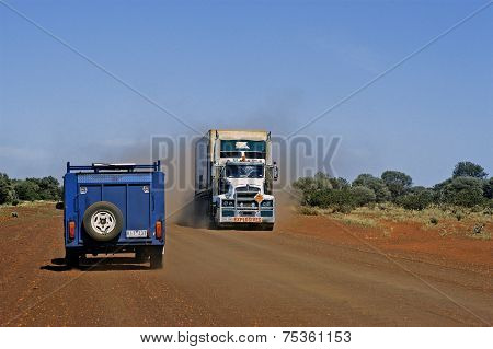 An All-terrain Vehicle With A Large Trailer Crossing A Truck Loaded With Explosives