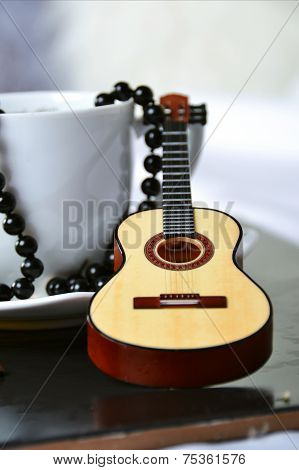 A small coffee cup with a decorative guitar
