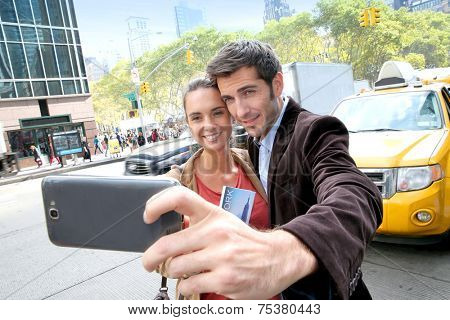 Couple in New York city taking picture with smartphone