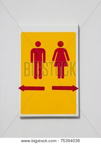 Women and men sign in front of public toilet