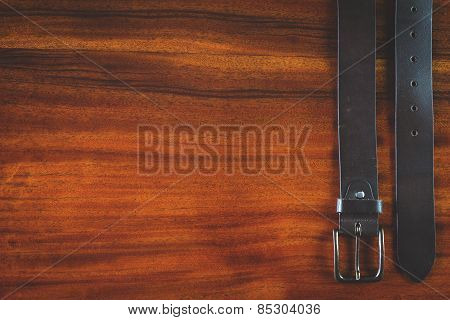 Mans leather belt on wooden table