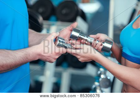 Beautiful girl in sports club with instructor