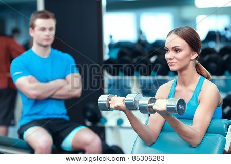 Beautiful girl in sports club with instructor