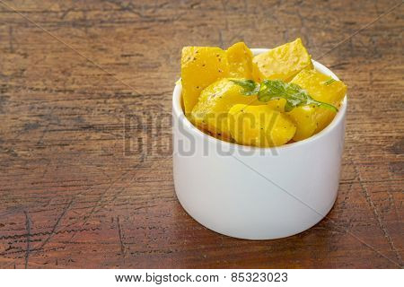 golden beet salad with arugula - small tasting bowl against rustic wood