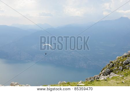 Paraglider Is Flying In Front Of Mountain Landscape Of Alps - Monte Baldo