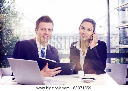 Happy businesspeople working at office on a sunny day. Lensflare.