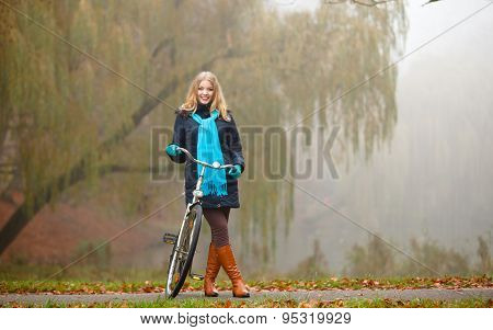 Girl Relaxing In Autumnal Park With Bicycle